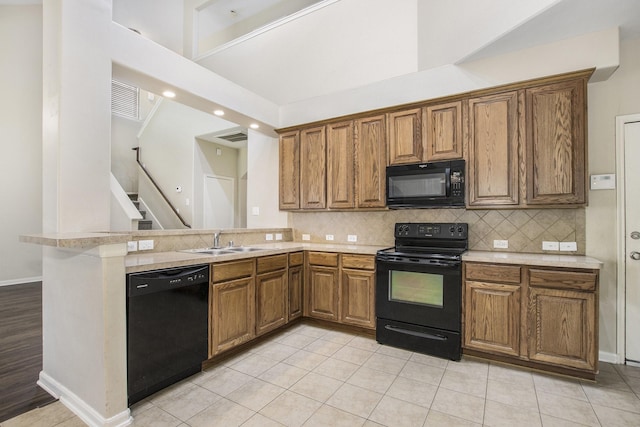 20515 Rustic Rail Ct, Cypress, TX 77433 - kitchen featuring black appliances, light countertops, brown cabinetry, a peninsula, and tasteful backsplash