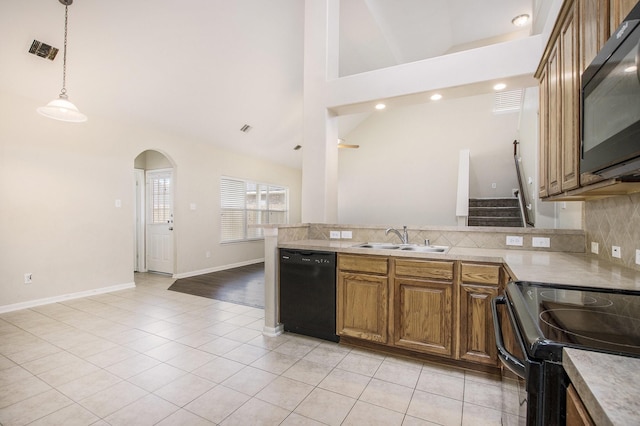 20515 Rustic Rail Ct, Cypress, TX 77433 - kitchen with black appliances, brown cabinetry, light tile patterned floors, backsplash, and a peninsula