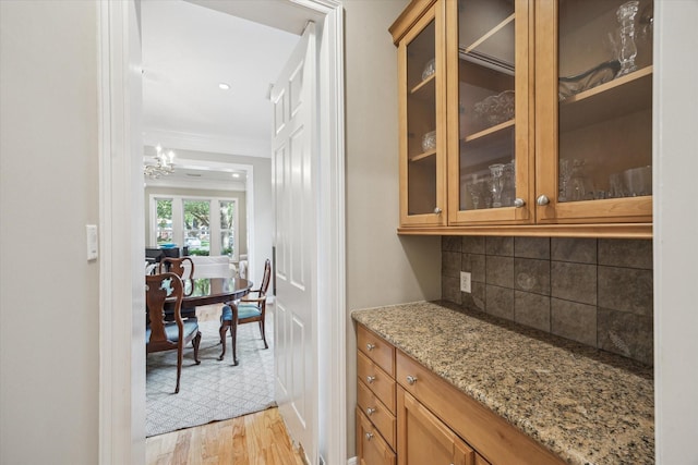 3614 University Blvd, West University Place, TX 77005 - bar area with decorative backsplash, light wood-style floors, a chandelier, and ornamental molding