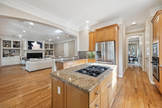 3614 University Blvd, West University Place, TX 77005 - kitchen featuring stainless steel appliances, a ceiling fan, a kitchen island, light stone countertops, and light wood-type flooring