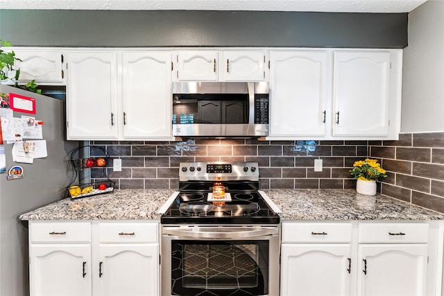 3426 Acorn Springs Ln, Spring, TX 77389 - kitchen featuring appliances with stainless steel finishes, white cabinetry, and decorative backsplash