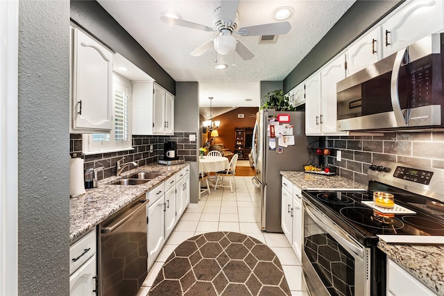 3426 Acorn Springs Ln, Spring, TX 77389 - kitchen featuring appliances with stainless steel finishes, white cabinetry, ceiling fan, recessed lighting, and a textured ceiling
