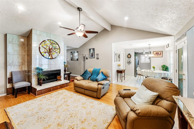 3426 Acorn Springs Ln, Spring, TX 77389 - living room with a textured ceiling, light wood-style flooring, a ceiling fan, a chandelier, and a fireplace