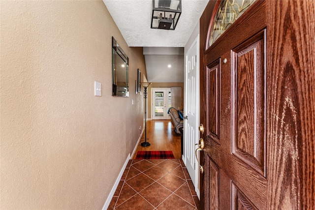 3426 Acorn Springs Ln, Spring, TX 77389 - hall featuring dark tile patterned flooring, a textured ceiling, and a textured wall