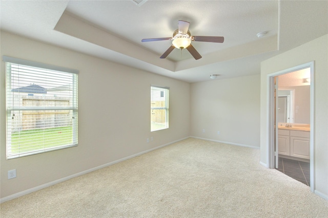 14839 Fir Knoll Way, Cypress, TX 77429 - unfurnished bedroom with a tray ceiling, carpet floors, ensuite bath, and a ceiling fan