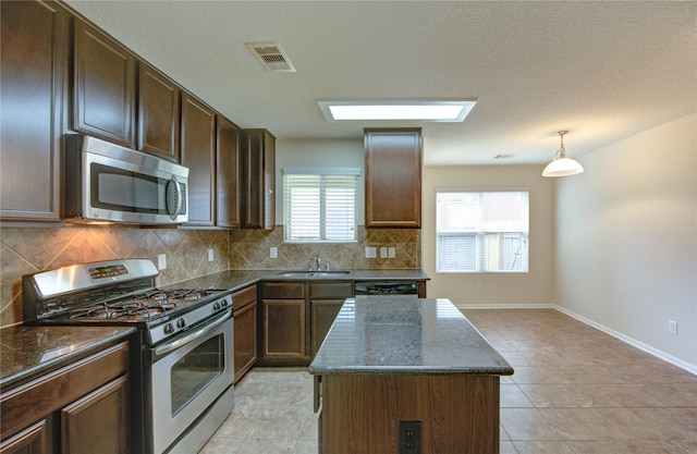 14839 Fir Knoll Way, Cypress, TX 77429 - kitchen with appliances with stainless steel finishes, decorative backsplash, dark stone counters, and a kitchen island