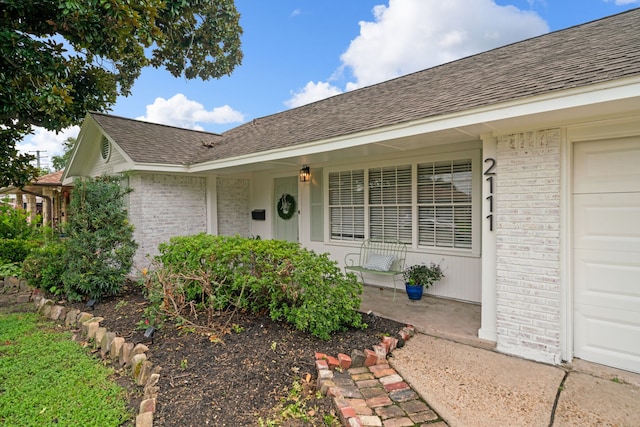 2111 Bron Holly Dr, Houston, TX 77018 - property entrance featuring brick siding, roof with shingles, and a garage