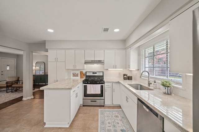 2111 Bron Holly Dr, Houston, TX 77018 - kitchen featuring stainless steel appliances, a peninsula, white cabinets, backsplash, and light tile patterned floors