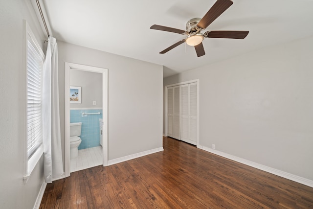 2111 Bron Holly Dr, Houston, TX 77018 - unfurnished bedroom with wood finished floors, a closet, tile walls, ensuite bath, and a ceiling fan