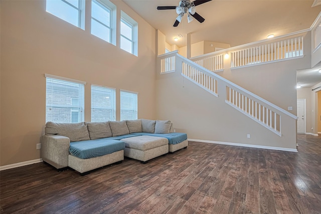 8134 Menorca Cove Dr, Cypress, TX 77433 - living room featuring a ceiling fan, a high ceiling, dark wood-style floors, and stairs