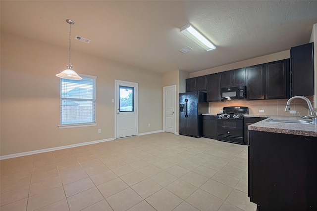 8134 Menorca Cove Dr, Cypress, TX 77433 - kitchen with black appliances, dark cabinets, light tile patterned flooring, pendant lighting, and decorative backsplash