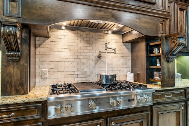 32723 Westminster Dr, Fulshear, TX 77441 - kitchen featuring stainless steel gas cooktop, dark brown cabinets, light stone counters, and tasteful backsplash