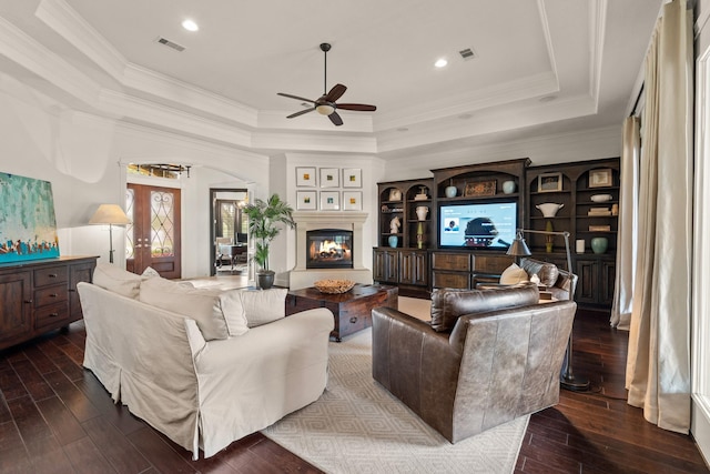 32723 Westminster Dr, Fulshear, TX 77441 - living room with a raised ceiling, ceiling fan, dark wood-style floors, ornamental molding, and arched walkways