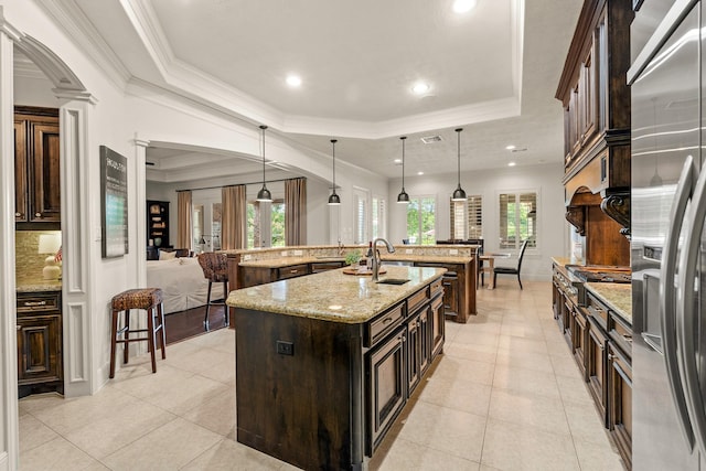 32723 Westminster Dr, Fulshear, TX 77441 - kitchen featuring a raised ceiling, built in refrigerator, a large island, light tile patterned floors, and crown molding