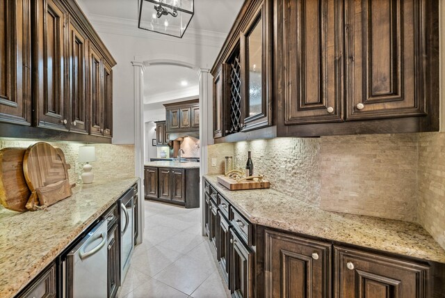 32723 Westminster Dr, Fulshear, TX 77441 - kitchen featuring crown molding, tasteful backsplash, dark brown cabinets, light stone counters, and light tile patterned flooring