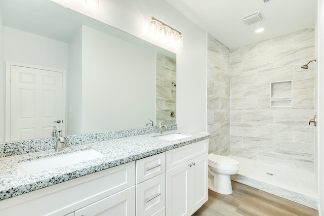 1927 Duncan Dr, Oyster Creek, TX 77541 - full bath with double vanity, a tile shower, wood finished floors, and recessed lighting