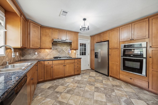 1905 17th Ave N, Texas City, TX 77590 - kitchen with stainless steel appliances, backsplash, brown cabinets, and stone finish floors