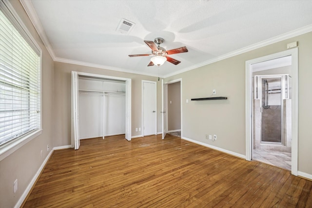 1905 17th Ave N, Texas City, TX 77590 - unfurnished bedroom featuring hardwood / wood-style floors, multiple closets, crown molding, ensuite bathroom, and ceiling fan