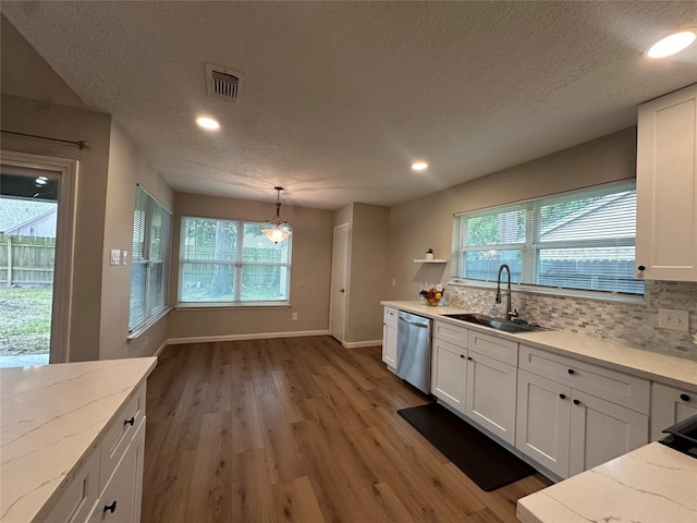 9219 Benwick Dr, Spring, TX 77379 - kitchen with dishwasher, white cabinets, light wood-type flooring, a textured ceiling, and healthy amount of natural light