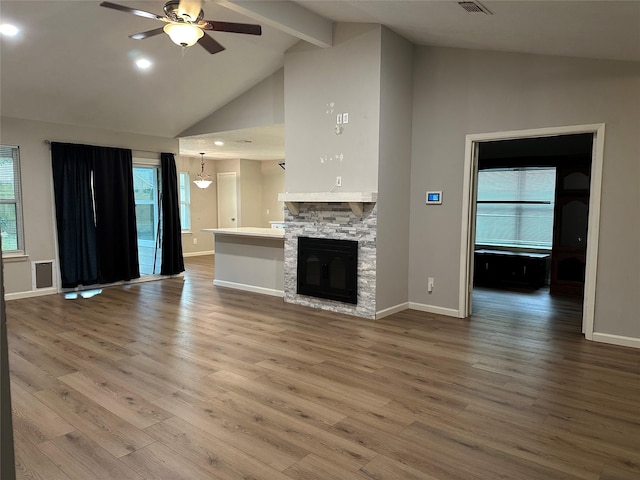 9219 Benwick Dr, Spring, TX 77379 - unfurnished living room with a ceiling fan, high vaulted ceiling, wood finished floors, beamed ceiling, and a stone fireplace