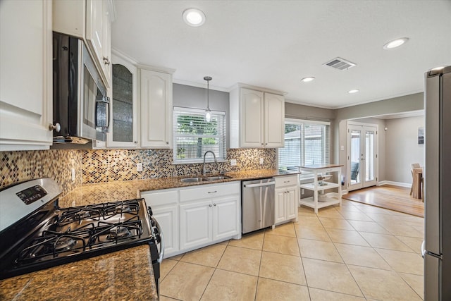 6518 Lindyann Ln, Houston, TX 77008 - kitchen with appliances with stainless steel finishes, light tile patterned flooring, crown molding, dark stone countertops, and decorative backsplash