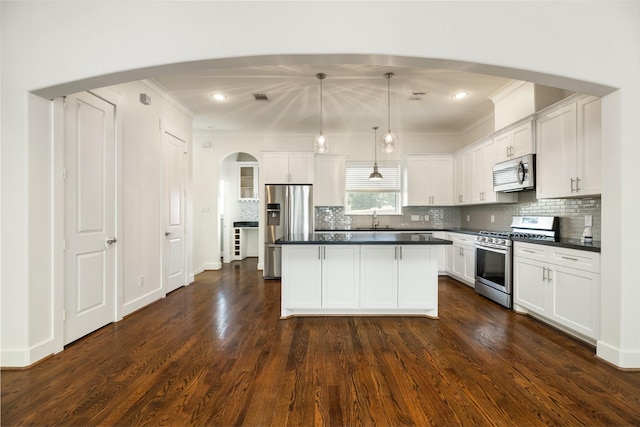 829 Wakefield Dr Unit A, Houston, TX 77018 - kitchen with appliances with stainless steel finishes, arched walkways, dark countertops, white cabinets, and ornamental molding