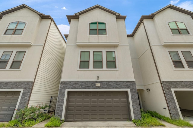 829 Wakefield Dr Unit A, Houston, TX 77018 - view of front of home featuring stone siding, an attached garage, and stucco siding