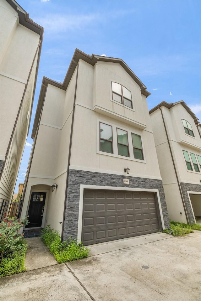829 Wakefield Dr Unit A, Houston, TX 77018 - view of front of house featuring stone siding, an attached garage, stucco siding, and concrete driveway