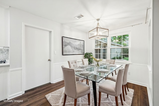 10014 Moorberry Ln, Houston, TX 77080 - dining area with dark wood-style floors, a wainscoted wall, a chandelier, and a decorative wall