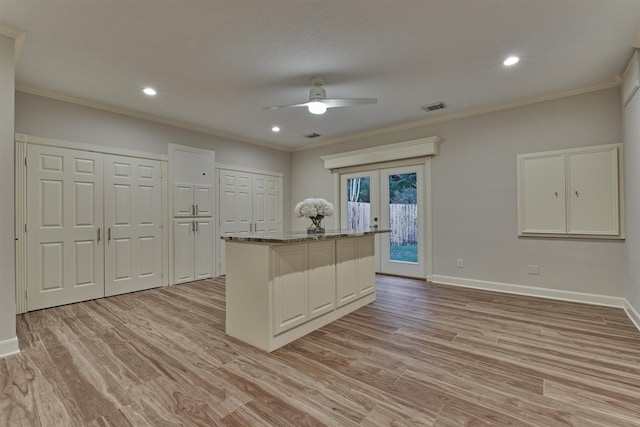 62 N Turtle Rock Ct, The Woodlands, TX 77381 - kitchen featuring ceiling fan, light wood-style floors, a center island, french doors, and ornamental molding
