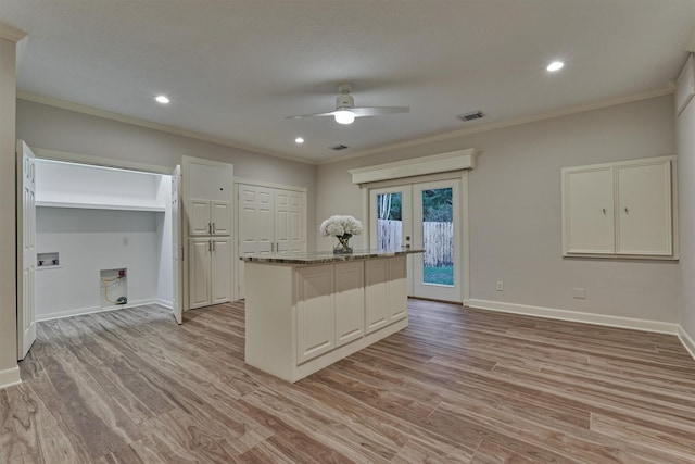 62 N Turtle Rock Ct, The Woodlands, TX 77381 - kitchen featuring ornamental molding, ceiling fan, a kitchen island, light wood-style flooring, and white cabinets