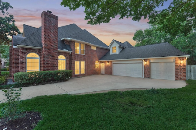 62 N Turtle Rock Ct, The Woodlands, TX 77381 - view of front of home featuring brick siding, a garage, driveway, a front lawn, and a chimney