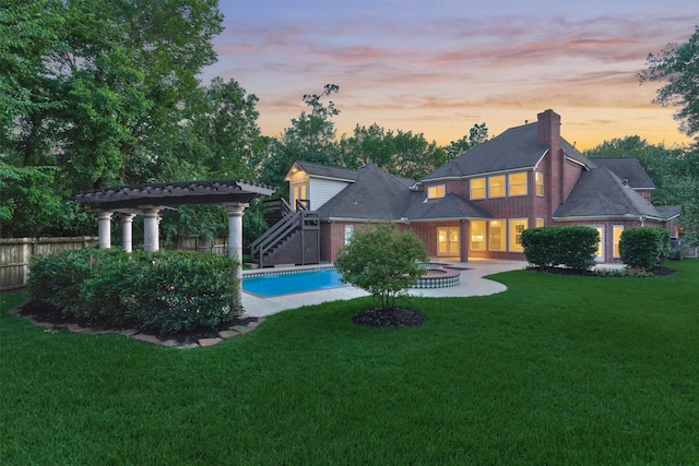 62 N Turtle Rock Ct, The Woodlands, TX 77381 - back of house at dusk featuring a chimney, stairs, and a fenced backyard