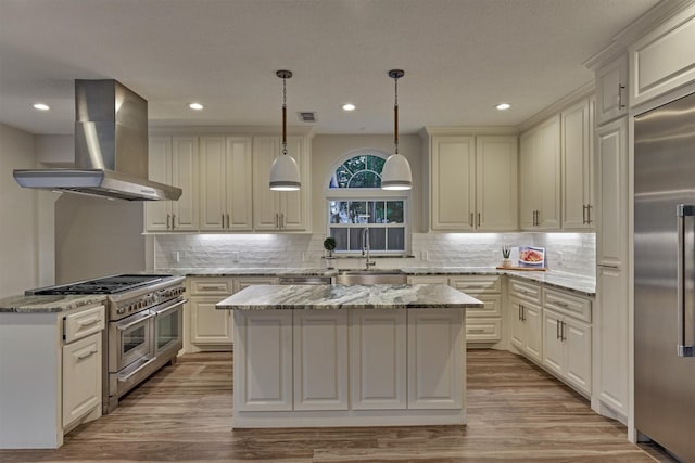 62 N Turtle Rock Ct, The Woodlands, TX 77381 - kitchen featuring wall chimney range hood, high quality appliances, light wood-type flooring, a kitchen island, and recessed lighting