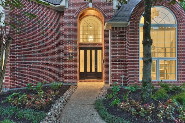 62 N Turtle Rock Ct, The Woodlands, TX 77381 - view of exterior entry with brick siding and a shingled roof
