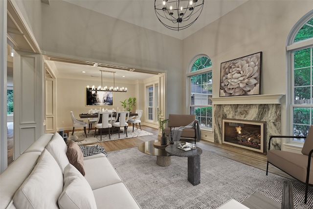 62 N Turtle Rock Ct, The Woodlands, TX 77381 - living area featuring a chandelier, wood finished floors, a towering ceiling, a high end fireplace, and ornamental molding