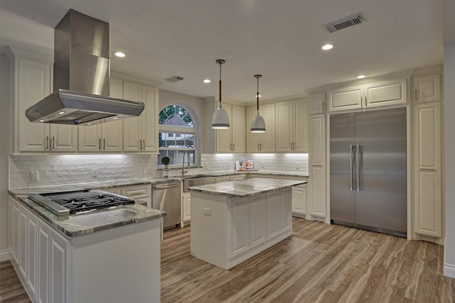 62 N Turtle Rock Ct, The Woodlands, TX 77381 - kitchen with stainless steel appliances, wall chimney range hood, light wood-type flooring, white cabinets, and recessed lighting