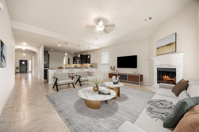 23414 Bracino Lake Dr, Katy, TX 77493 - living area with a ceiling fan, arched walkways, a glass covered fireplace, and recessed lighting