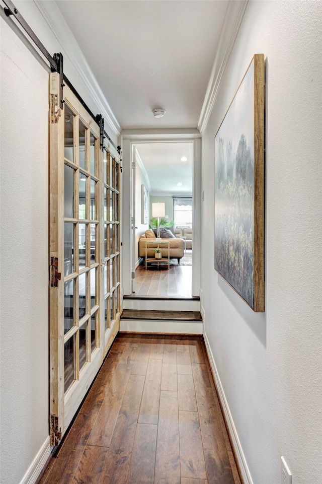 3739 University Blvd, Southside Place, TX 77005 - corridor with ornamental molding, a barn door, and hardwood / wood-style floors