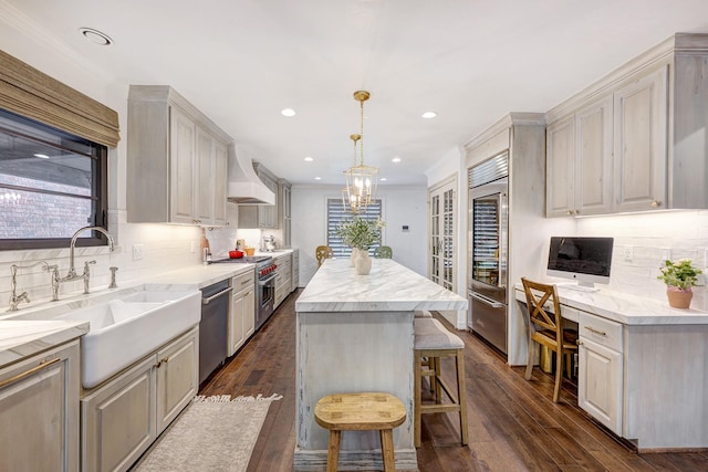 3739 University Blvd, Southside Place, TX 77005 - kitchen with premium appliances, premium range hood, dark wood-style floors, a center island, and decorative backsplash