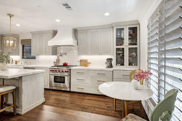 3739 University Blvd, Southside Place, TX 77005 - kitchen with custom exhaust hood, premium range, decorative backsplash, dark wood-style flooring, and glass insert cabinets