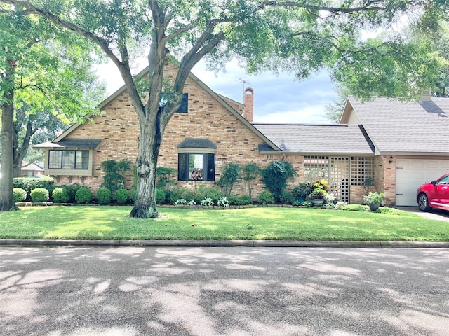 1706 23rd Ave N, Texas City, TX 77590 - view of front of home with an attached garage, brick siding, a chimney, and a front yard