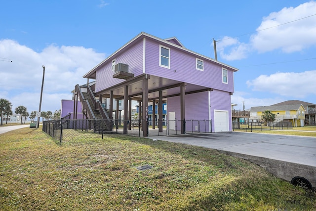 23101 Camino St, Galveston, TX 77554 - back of property featuring an attached garage, concrete driveway, and stairway