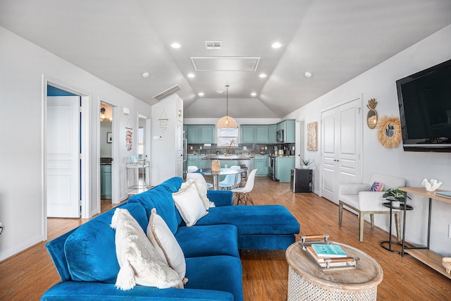 23101 Camino St, Galveston, TX 77554 - living room featuring vaulted ceiling, attic access, light wood-style floors, and recessed lighting