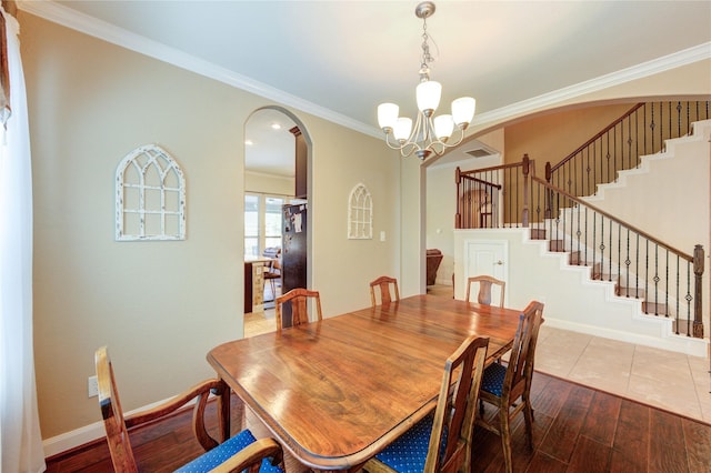19723 Alton Springs Dr, Cypress, TX 77433 - dining space featuring arched walkways, stairway, a chandelier, hardwood / wood-style floors, and ornamental molding