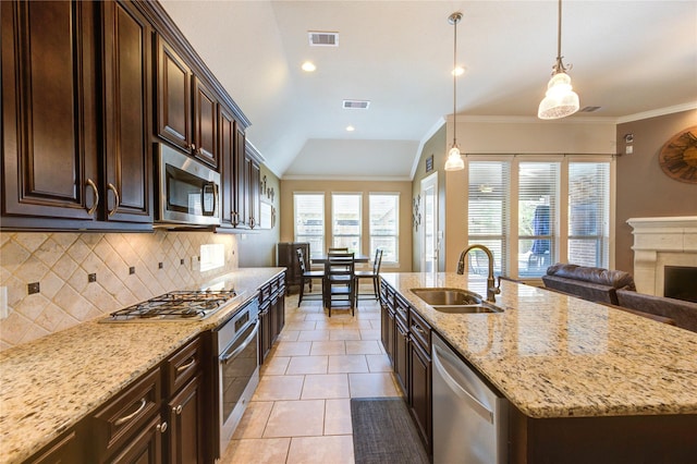 19723 Alton Springs Dr, Cypress, TX 77433 - kitchen featuring stainless steel appliances, tasteful backsplash, light stone countertops, dark brown cabinetry, and light tile patterned floors