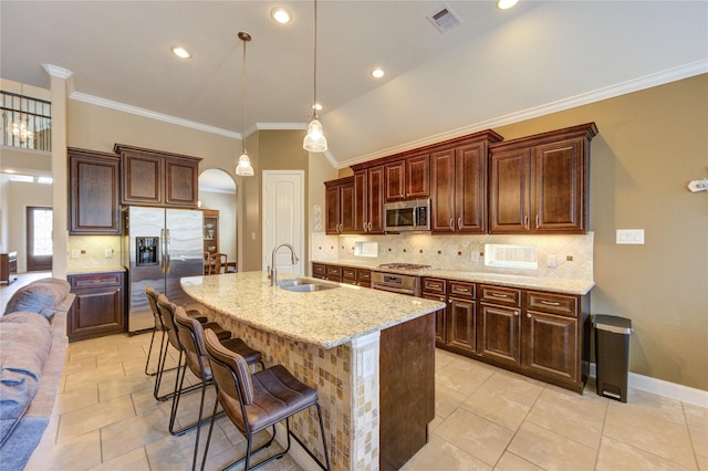 19723 Alton Springs Dr, Cypress, TX 77433 - kitchen featuring appliances with stainless steel finishes, arched walkways, a kitchen bar, light stone counters, and backsplash