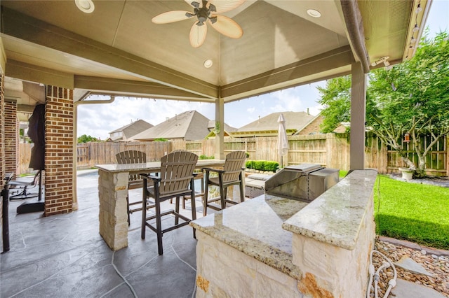 19723 Alton Springs Dr, Cypress, TX 77433 - fenced backyard featuring a patio, an outdoor kitchen, and a ceiling fan