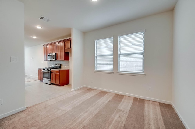 18822 Fulvetta Haven Way, Richmond, TX 77407 - kitchen featuring appliances with stainless steel finishes, light colored carpet, brown cabinets, decorative backsplash, and recessed lighting