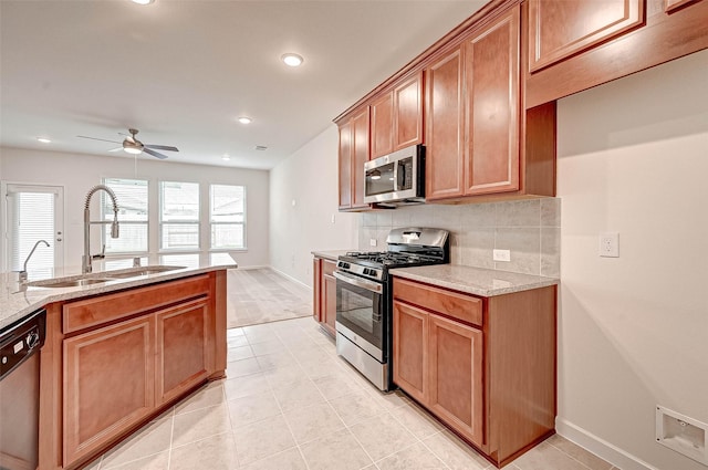 18822 Fulvetta Haven Way, Richmond, TX 77407 - kitchen with stainless steel appliances, backsplash, a ceiling fan, light stone countertops, and recessed lighting